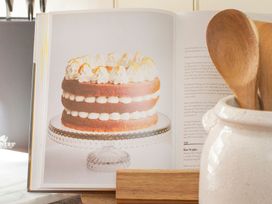A recipe book open to a cake on display with wooden spoons in a jar at Apartment 2, 86 Dyer Street Cirencester