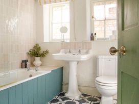 A bathroom with a bathtub, sink, and toilet at Apartment 2, 86 Dyer Street, Cirencester