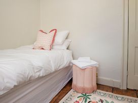 A bedroom with a bed and decorative stool at Apartment 2, 86 Dyer Street Cirencester