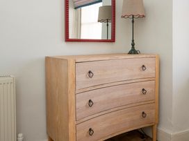 A dresser with a mirror and lamp in a bedroom at Apartment 2, 86 Dyer Street, Cirencester