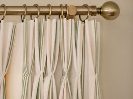 A curtain with green and white stripes in Apartment 2, 86 Dyer Street Cirencester