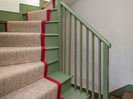 A staircase with carpet and handrail at Apartment 2, 86 Dyer Street Cirencester