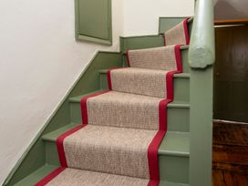 A staircase with a carpet runner at Apartment 2, 86 Dyer Street Cirencester