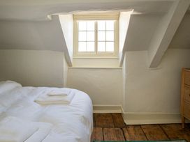 A bedroom with a bed and a window at Apartment 2, 86 Dyer Street Cirencester