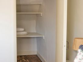 A storage room with shelves and bedding at Apartment 2, 86 Dyer Street Cirencester