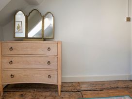 A dresser with a mirror and a picture in Apartment 2, 86 Dyer Street Cirencester