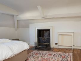 A bedroom with a bed and a fireplace at Apartment 2, 86 Dyer Street, Cirencester