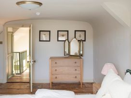 A bedroom with a dressing table and door leading to stairs at Apartment 2, 86 Dyer Street Cirencester