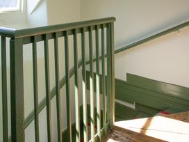 A staircase with a railing and wooden steps at Apartment 2, 86 Dyer Street Cirencester