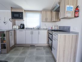 A kitchen with cabinets and appliances at V9 Ty Mawr Holiday Park