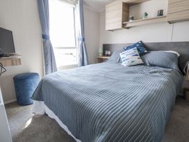 A bedroom with a bed and television at V9 Ty Mawr Holiday Park 