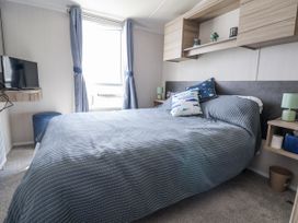 A bedroom with a bed and television at V9 Ty Mawr Holiday Park