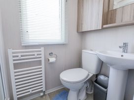 A bathroom with a sink, toilet, and radiator at V9 Ty Mawr Holiday Park
