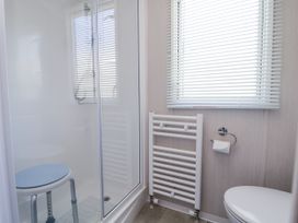 A bathroom with a shower and toilet at V9 Ty Mawr Holiday Park