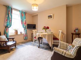 A dining room with a table and chairs at Bwthynbach in Porthmadog