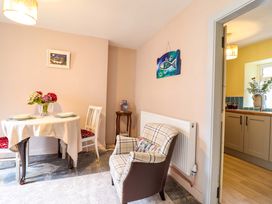 A dining room with a table and chairs at Bwthynbach in Porthmadog