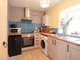 A kitchen with appliances and wooden countertops at Bwthynbach Porthmadog