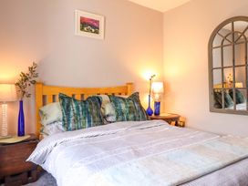 A bedroom with a bed and bedside lamps at Bwthynbach in Porthmadog