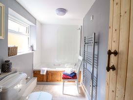 A bathroom with a bath tub and a toilet at Bwthynbach in Porthmadog