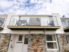 A balcony with glass railings and stone exterior at 9 Slipway Cottages Rock