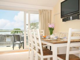 A dining room with a table and chairs at 9 Slipway Cottages in Rock
