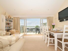 A living room with a sofa and dining table at 9 Slipway Cottages in Rock