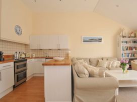 A kitchen with a couch and shelves at 9 Slipway Cottages Rock