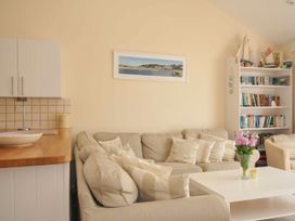 A living room with a sofa and coffee table at 9 Slipway Cottages in Rock