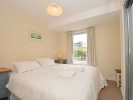 A bedroom with a bed and nightstand at 9 Slipway Cottages in Rock