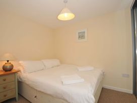 A bedroom with a bed and bedside table at 9 Slipway Cottages Rock