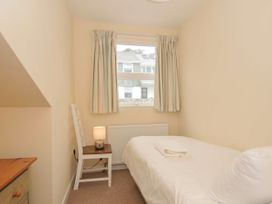 A bedroom with a bed and lamp at 9 Slipway Cottages in Rock