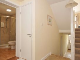 A bathroom with a shower and toilet at 9 Slipway Cottages in Rock