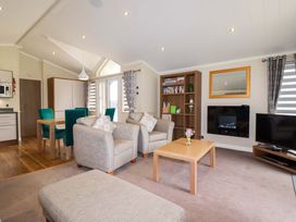 A living room with a sofa and dining area at The Maples 44 St. Austell