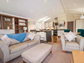 A living room with a sofa and dining area at The Maples 44 St. Austell