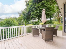 An outdoor area with a table and chairs under an umbrella at The Maples 44 St. Austell