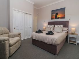 A bedroom with a bed, chair and wardrobe at Sandy Shore in Bridlington