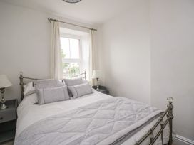 A bedroom with a bed and a window at Billy's Cottage in Maryport