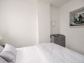 A bedroom with a bed and side table at Billy's Cottage in Maryport