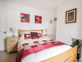 A bedroom with a bed and bedside table at Billy's Cottage in Maryport