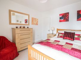 A bedroom with a bed and dresser at Billy's Cottage in Maryport