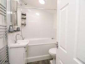 A bathroom with a bathtub, toilet, and sink at Billy's Cottage in Maryport