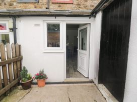 An entrance area with a door and potted plants at Billy's Cottage in Maryport
