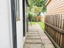 An outdoor pathway with a chair and fence at Billy's Cottage in Maryport