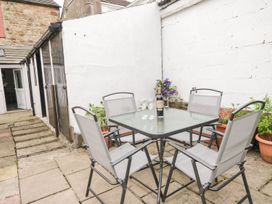 A garden area with a table and chairs at Billy's Cottage in Maryport