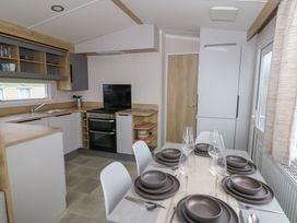 A kitchen with a dining table set at Hafan Y Mor Aberporth