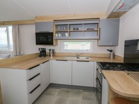 A kitchen with appliances and fixtures at Hafan Y Mor in Aberporth