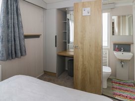 A bedroom with a bed and a bathroom area at Hafan Y Mor in Aberporth