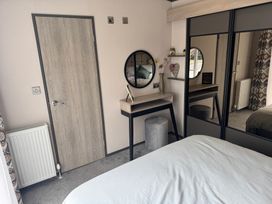 A bedroom with a desk and mirror at Lime Tree Lodge