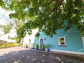 A house with a blue wall and plants in pots at Ash House in Ballyvaughan