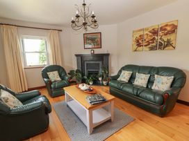 A living room with green sofas and a coffee table at Ash House in Ballyvaughan